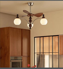 Ceiling fan with light fixture in a room with wooden cabinets and a window.