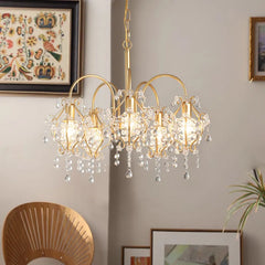 Close-up view of the gold crystal chandelier, highlighting the intricate design of the crystal droplets and the brushed gold metalwork.
