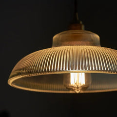 Vintage-style pendant light with a ribbed glass shade on a dark background