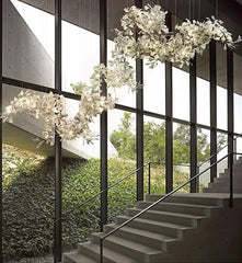Modern staircase with large windows and decorative white flowers hanging from the ceiling.