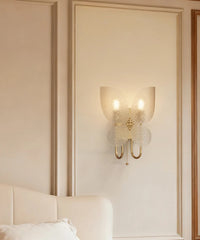 Decorative wall sconce on a wall with a bed in the foreground