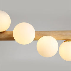 Ceiling light fixture with wooden bar and round glass shades on a gray background