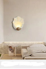 Shell-shaped wall light fixture in a bedroom setting with neutral tones.