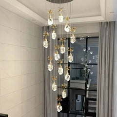 Modern chandelier with crystal lights in a room with light-colored walls and a glass door.