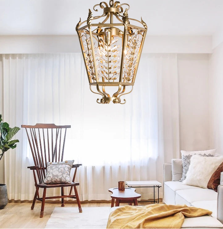 Living room with a decorative gold ceiling light fixture, white sofa, wooden chair, and small table.