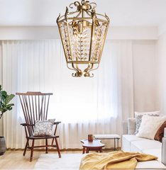 Living room with a decorative gold ceiling light fixture, white sofa, wooden chair, and small table.