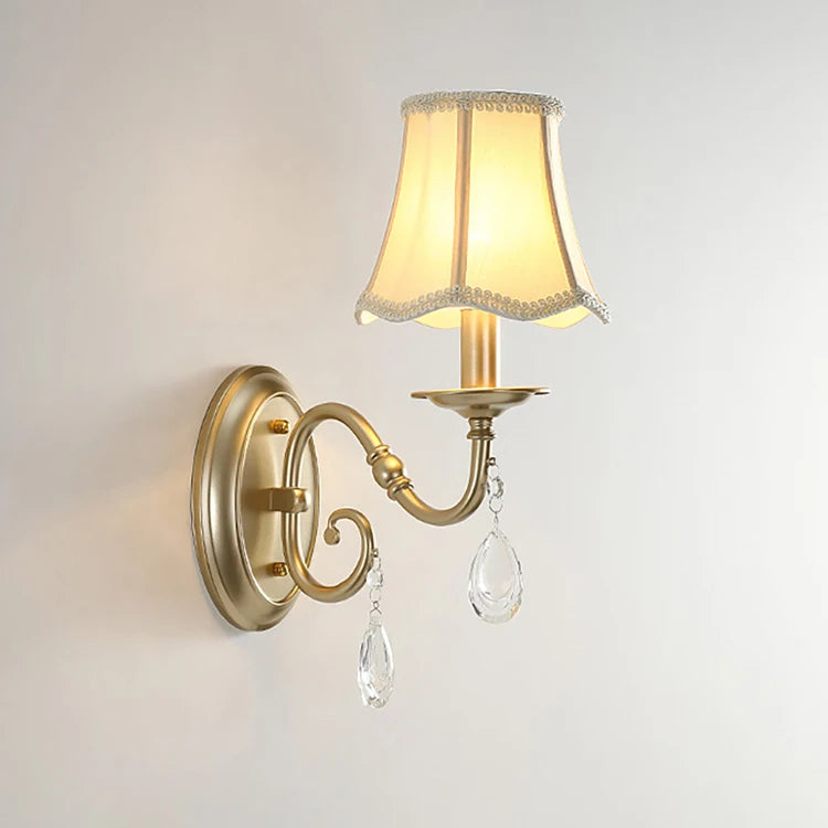Wall-mounted lamp with a decorative shade and crystal accents on a plain background