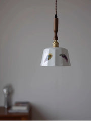 Pendant light with decorative shade on a plain wall