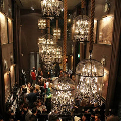 Luxurious interior with hanging chandeliers and people socializing.