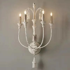 Vintage-style wall sconce with multiple candle-like lights on a plain background