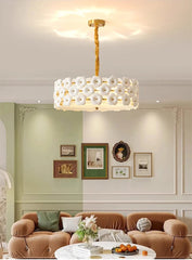 Modern living room with a stylish chandelier, brown sofa, and decorative wall art.