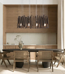 Modern dining room with a long table and chairs, featuring a stylish chandelier.