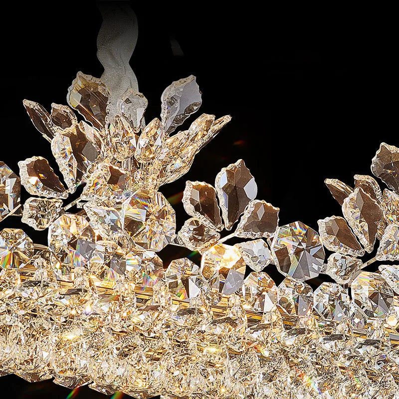 Detail shot of the crystal and floral elements on the polished chrome chandelier, with visible light refractions.
