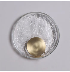 Decorative wall light fixture with gold sphere on a gray background