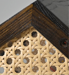 Close-up of a corner with wooden frame and woven wicker design.