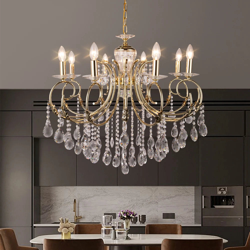 A gold candelabra crystal chandelier installed in a modern dining room setting above a table.