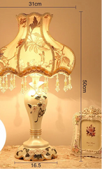 Decorative table lamp with floral design and measurements on a neutral background