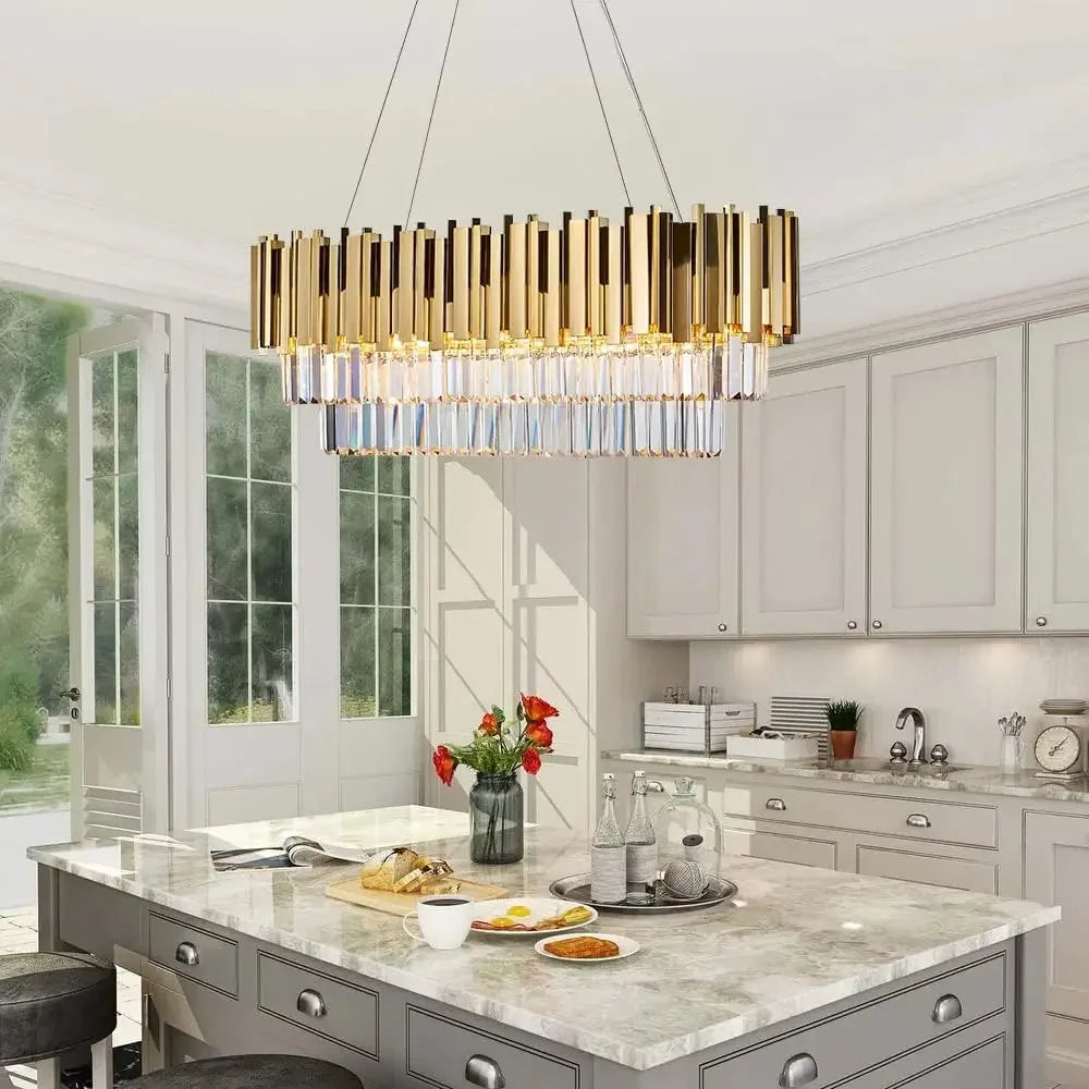 Gold and crystal multi-tier rectangular chandelier hanging above a marble kitchen island.