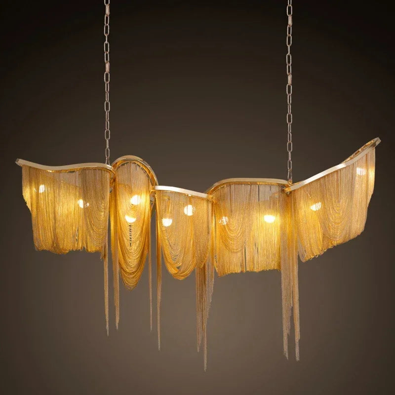 Gold aluminum chain tassel pendant light with warm illumination, shown in a lifestyle setting.