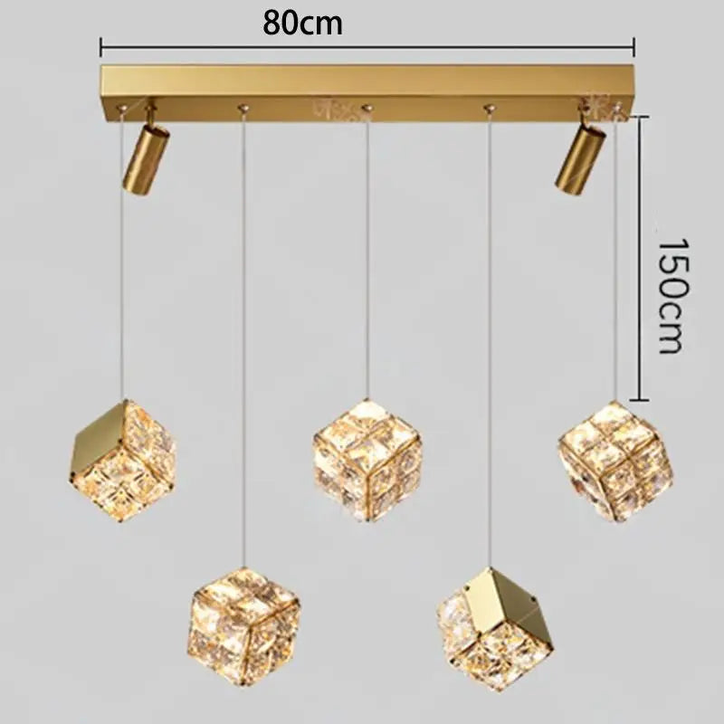 Gold pendant light fixture with crystal-like shades and measurements on a gray background