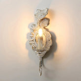 Decorative wall sconce with a candle-like light on a plain background