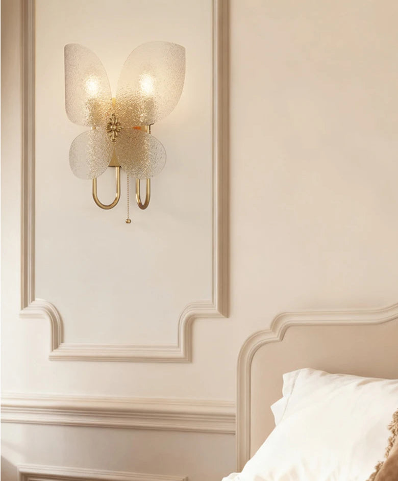 Decorative wall sconce on a wall with a bed in the foreground