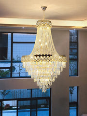 A wide shot of a gold crystal chandelier in a modern interior, highlighting its scale and opulent design.