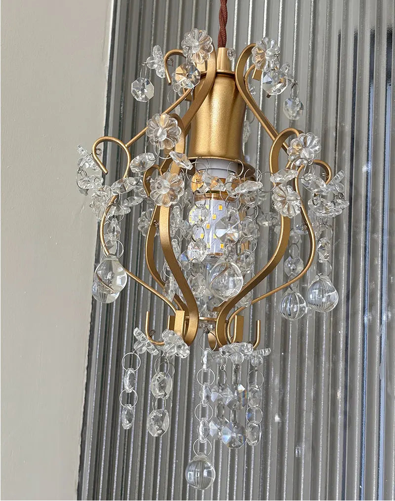 Gold chandelier with crystal accents against a neutral background