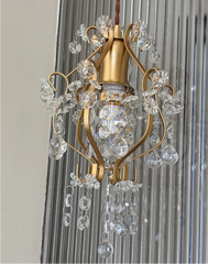 Gold chandelier with crystal accents against a neutral background