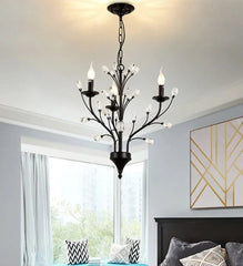 Black chandelier hanging in a bedroom with light on