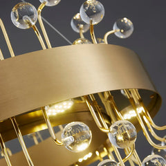 Detailed view of the gold finish and clear crystal elements on a chandelier.