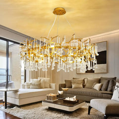A wide view of a living room featuring a large gold branch crystal chandelier as the central light fixture.