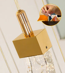 Gold pendant light fixture with a close-up of a hand holding a lighter.
