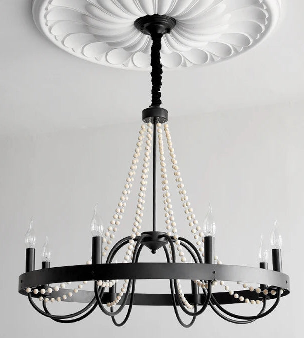 Black chandelier with pearl-like strands on a gray background