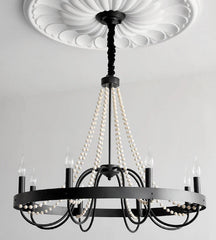 Black chandelier with pearl-like strands on a gray background