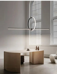 Modern pendant light hanging above a desk in a minimalistic room.