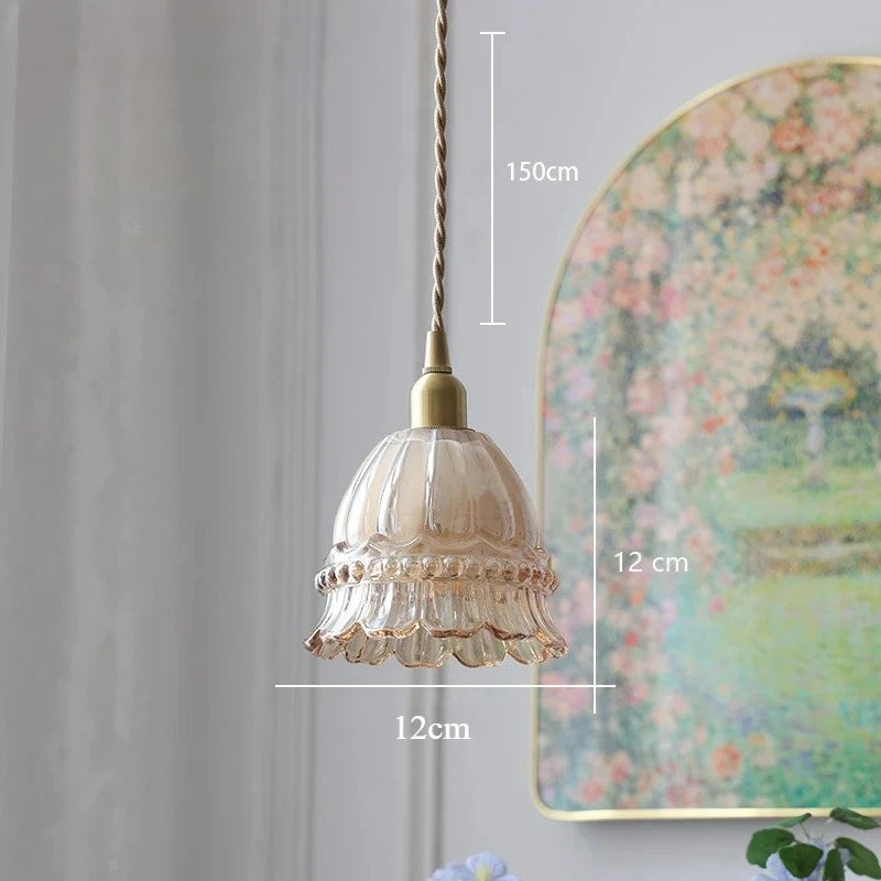 Decorative pendant light with measurements against a wall with a floral painting.