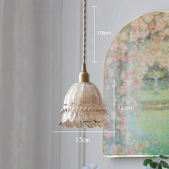 Decorative pendant light with measurements against a wall with a floral painting.