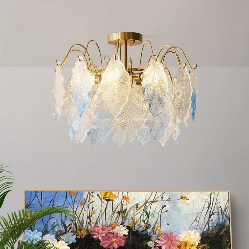 Decorative ceiling light fixture with leaf-like shades on a plain wall.