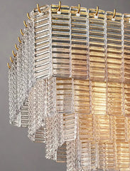 Decorative chandelier with glass panels and gold accents on a gray background