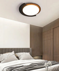 Ceiling light fixture in a bedroom setting with bed and wardrobe.