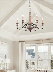 Chandelier hanging in a room with large windows and neutral decor