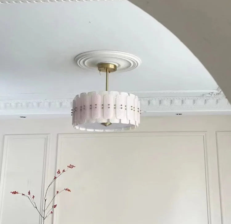 Ceiling light fixture in a room with white walls and decorative molding.