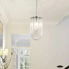 A single chrome U-shaped pendant light with clear glass tubes hanging in a hallway with a staircase.