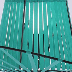 Close-up of green metal slats with a white background.