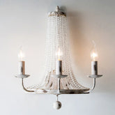 Decorative chandelier with three candle-style lights on a plain background