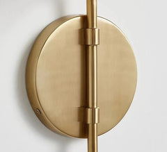 Brass wall-mounted light fixture on a white background