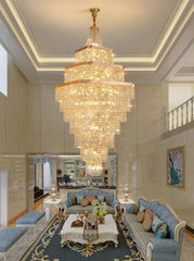 Luxurious living room with a grand chandelier, blue sofa, and decorative elements.