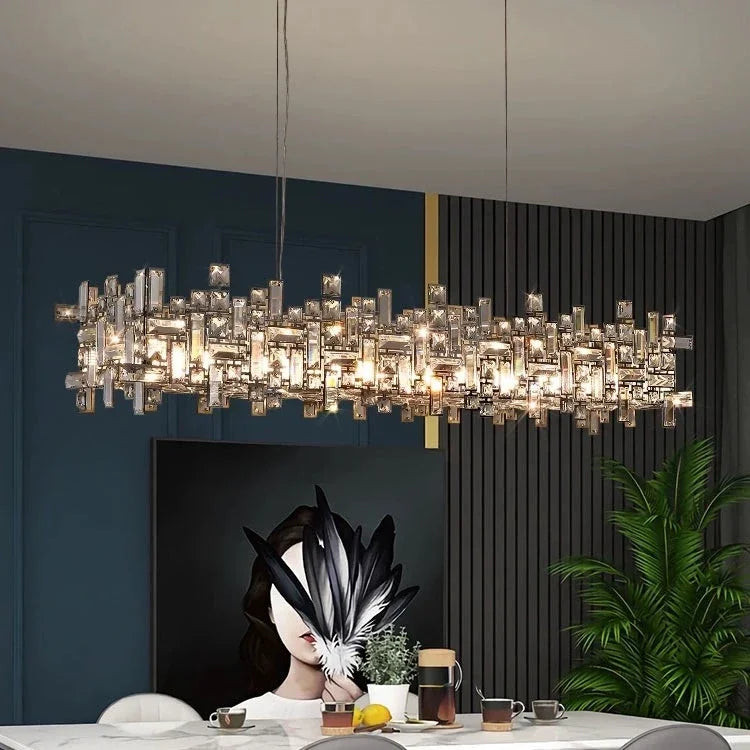 Modern chandelier hanging above a dining table with decor items.
