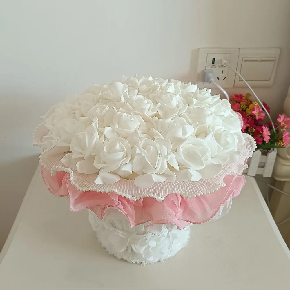 White floral arrangement with pink ruffles on a white surface